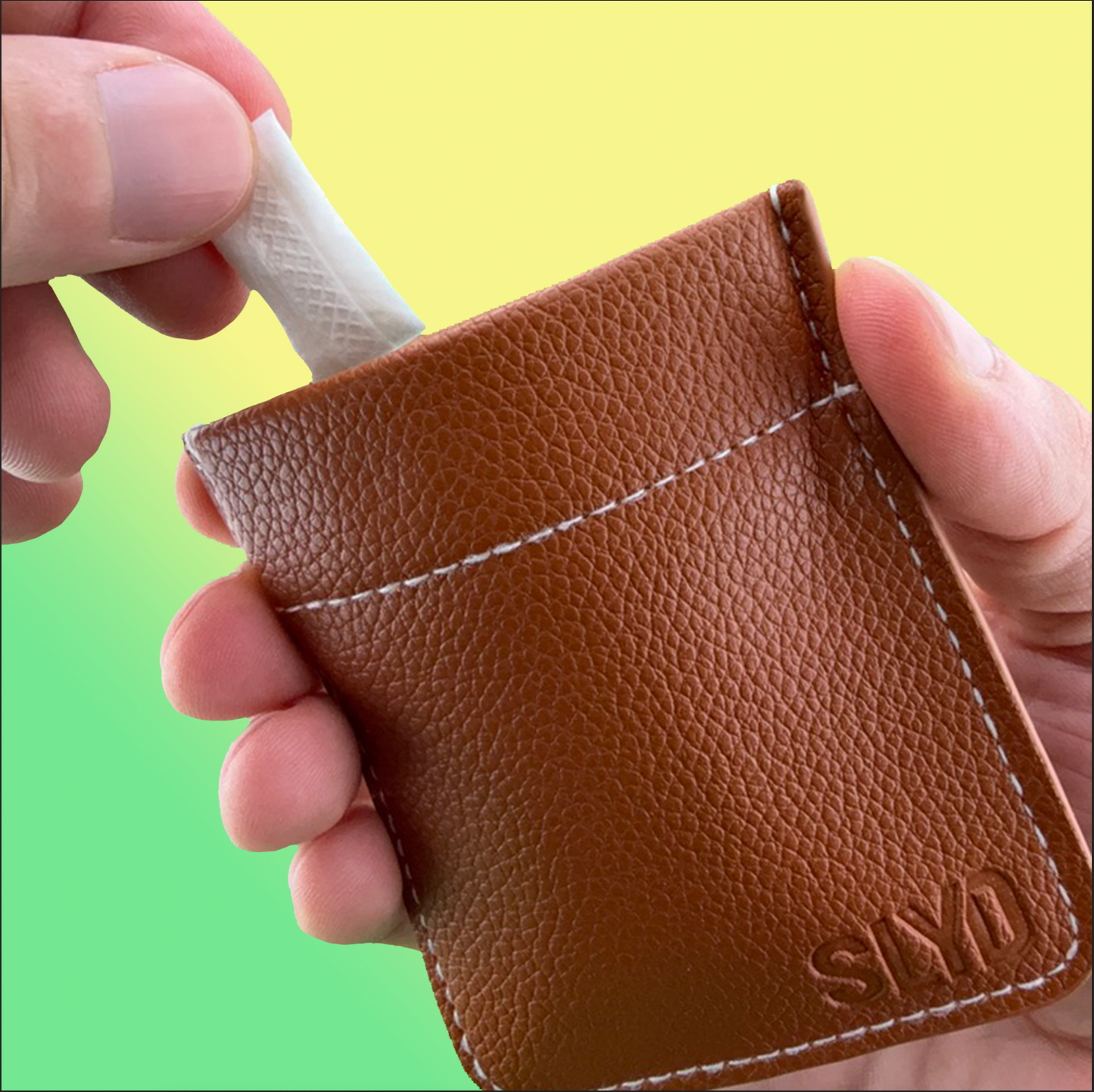 Brown leather wallet with 'SLYD' branding held by a hand against a gradient background